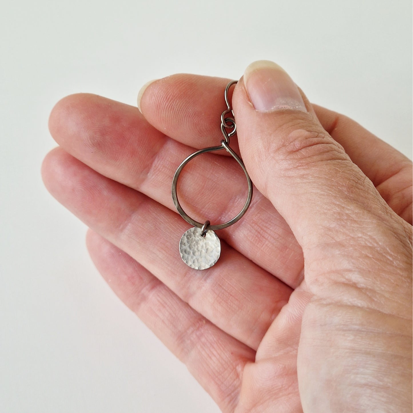 Titanium Earrings Open Circle with Tiny Disc on Hand