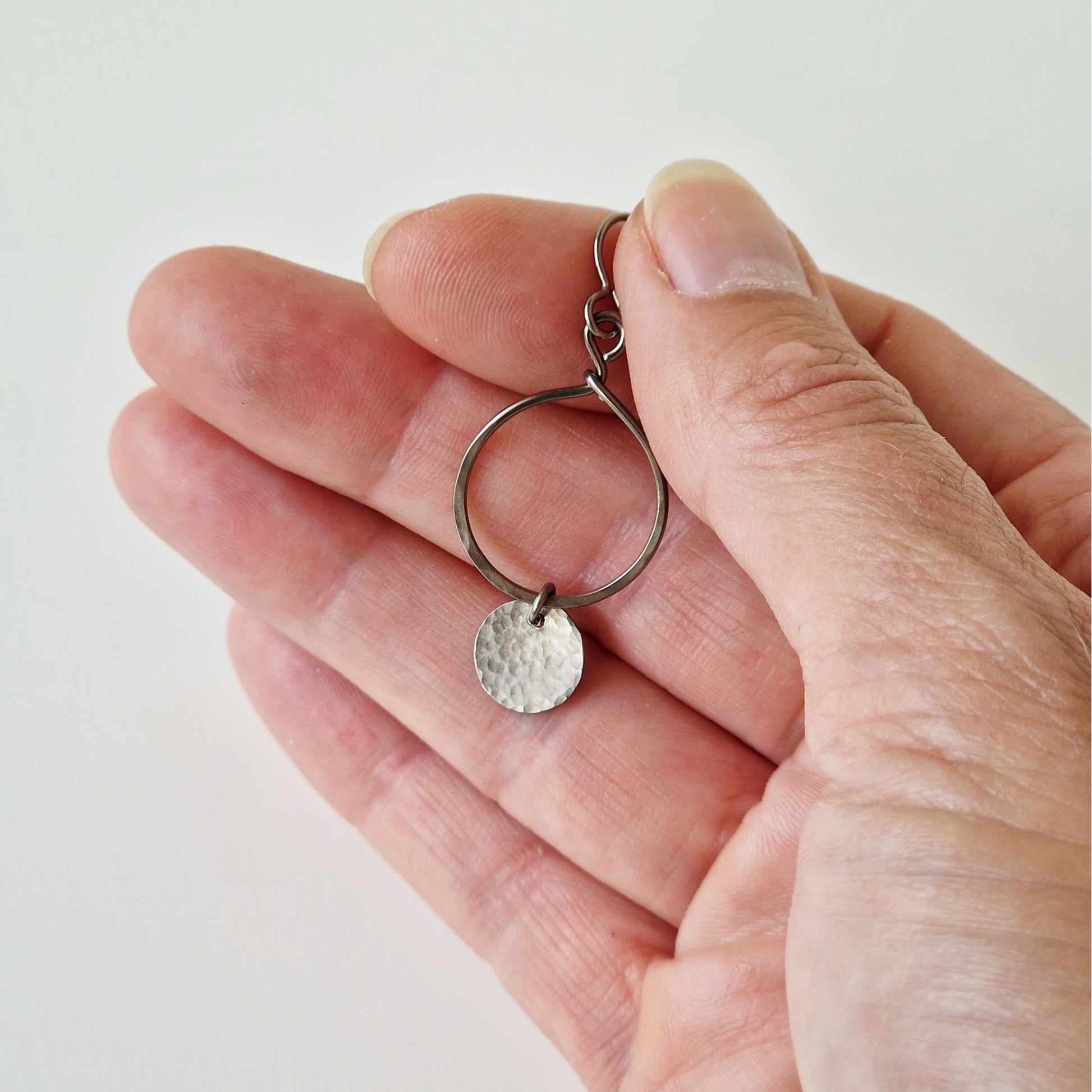 Titanium Earrings Open Circle with Tiny Disc on Hand