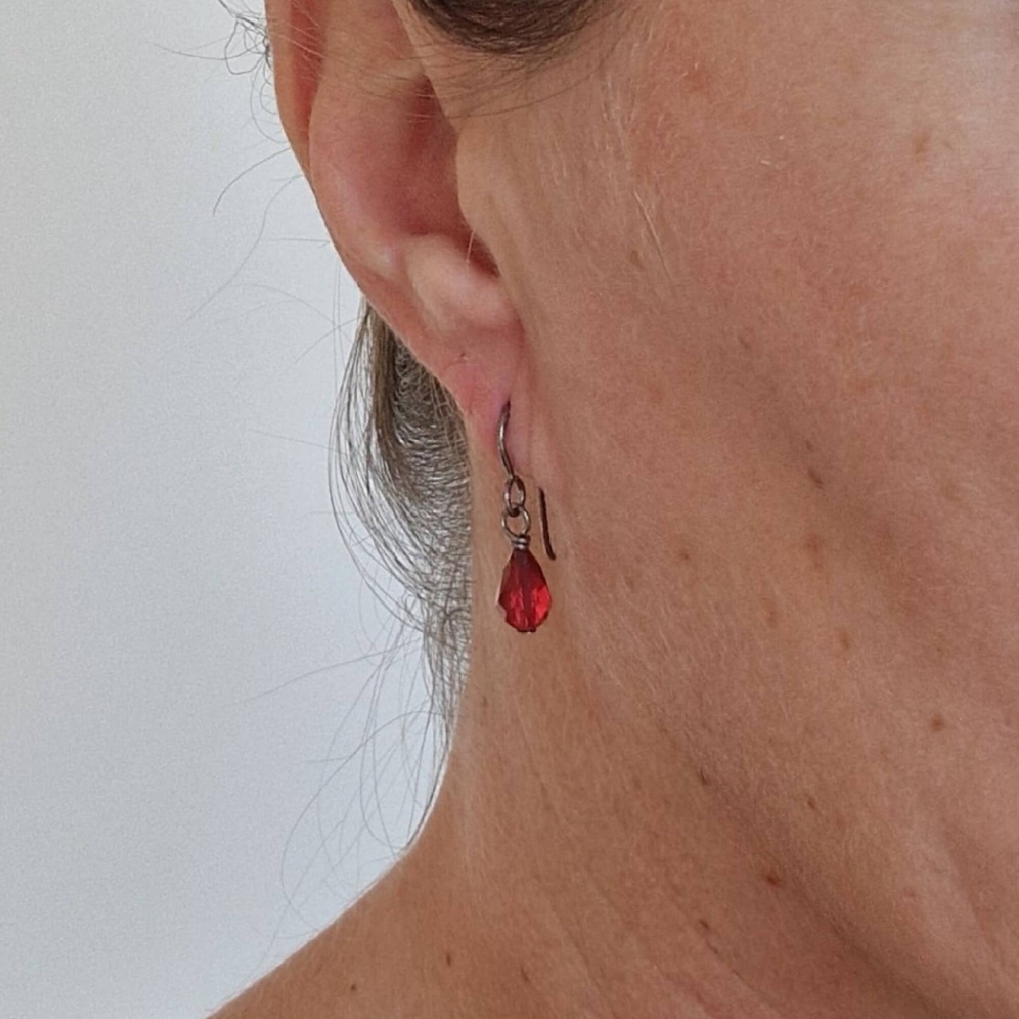 Pure Titanium Earrings with Ruby Red Crystal Teardrops Shown in Ear